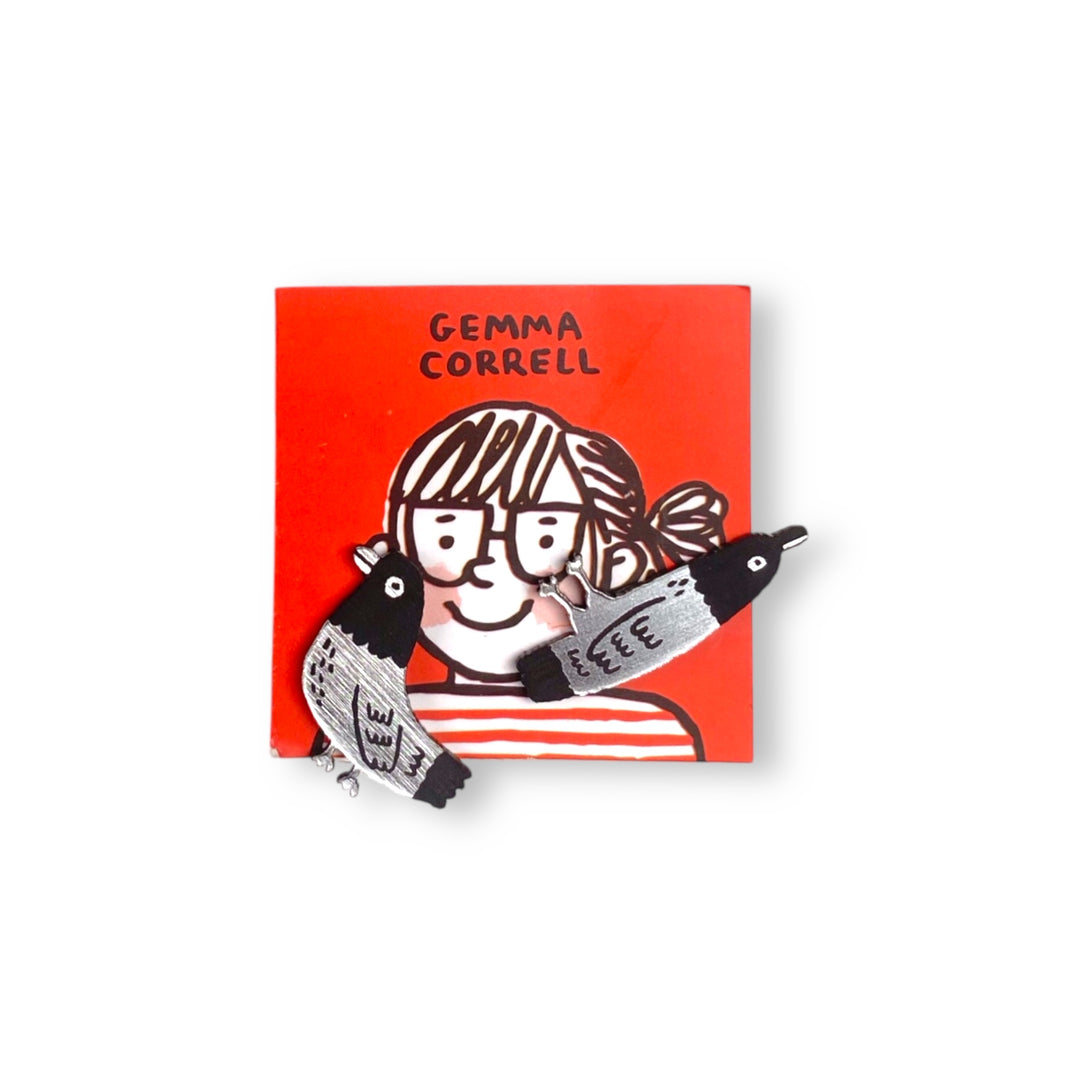 Asymmetrical Pigeon stud earrings illustrated by Gemma Correll on a red branded card and set on a white background.