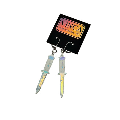 Dangly switchblade earrings on a Vinca branded black card.