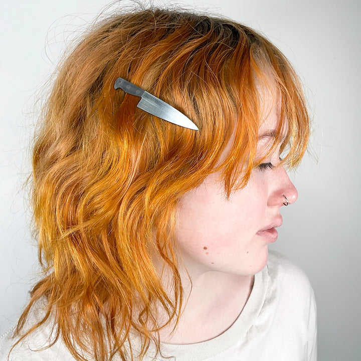 A young woman wears Vinca's 3" Chef's Knife hair clip in her hair. 