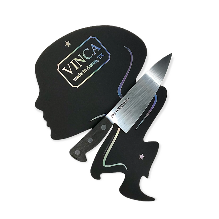 "No Touching" is etched on Vinca's plastic 3" Chef's Knife Barrette and clasped onto a Vinca packaging card on a white background.