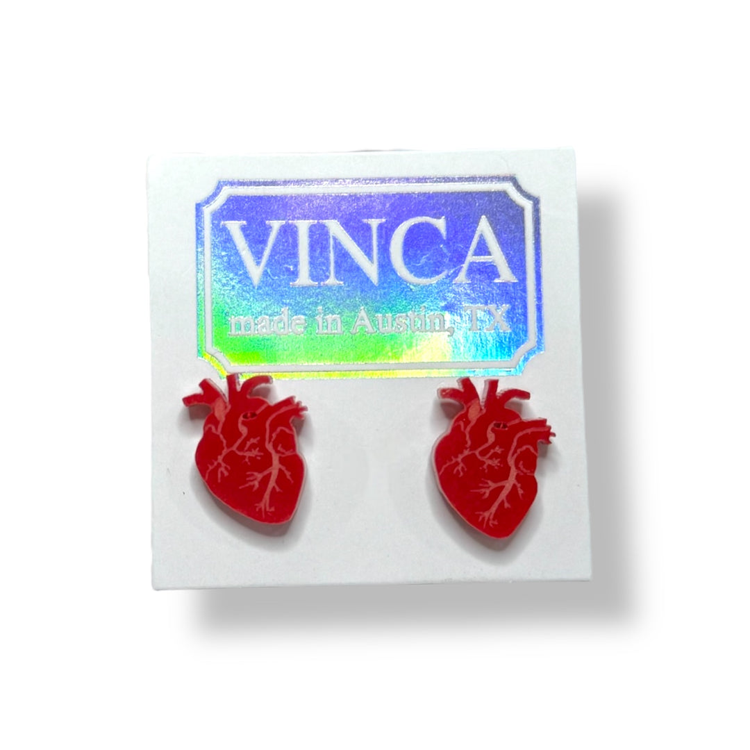 Anatomical heart earrings in solid red on a white card and set against a white background