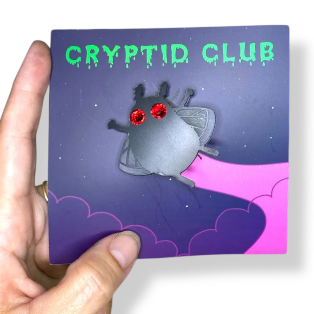 Sarah's Scribbles Cryptid Club Mothman design on a branded card held against a white background.
