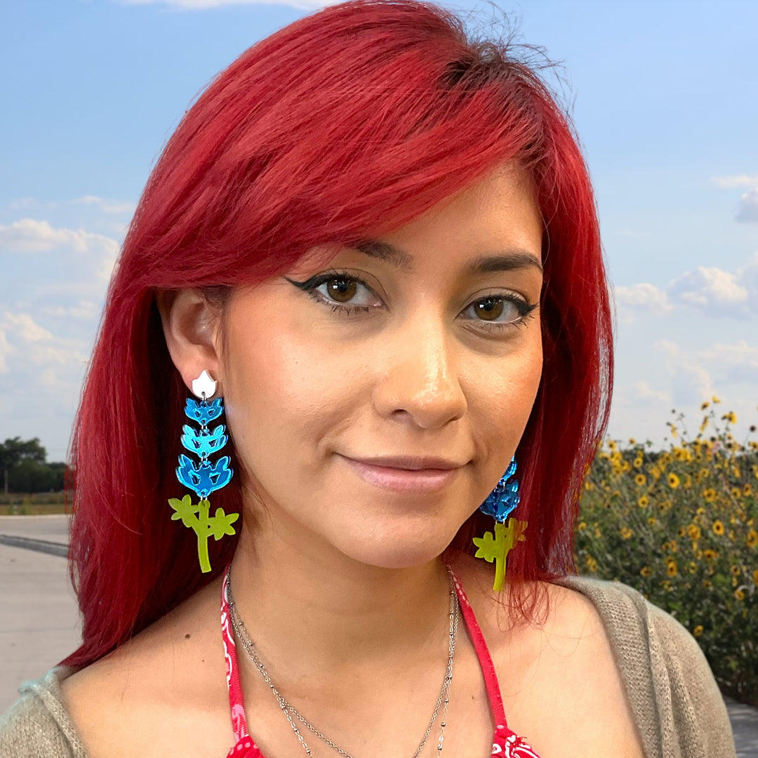 Extra large Texas bluebonnet flower earrings on a model with bright red hair.