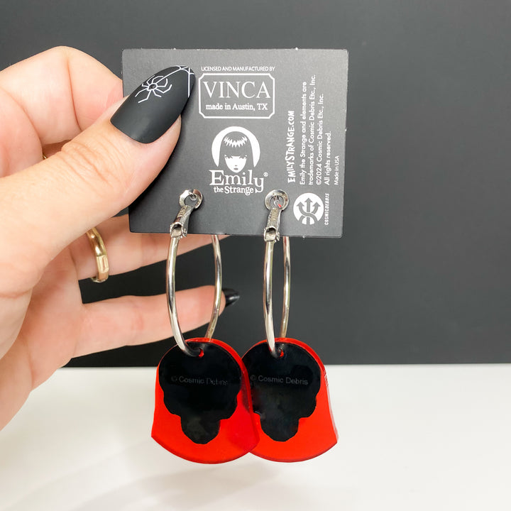 A hand holds the back side of our officially licensed Emily the Strange X-Ray Emily Skull Hoop Earrings set against a white and black background. 