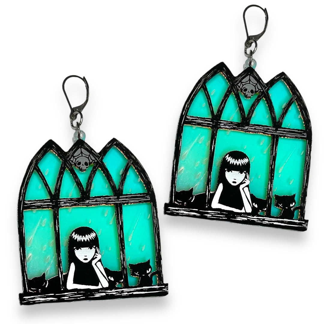 Officially licensed Emily the Strange soft goth iridescent window earrings on a white background.