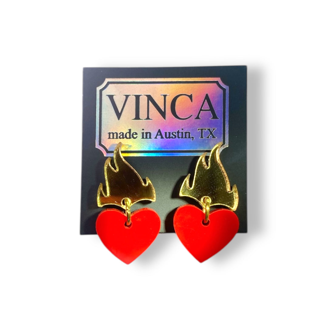 flaming heart earrings in solid red and mirror gold on a black card against a white background.