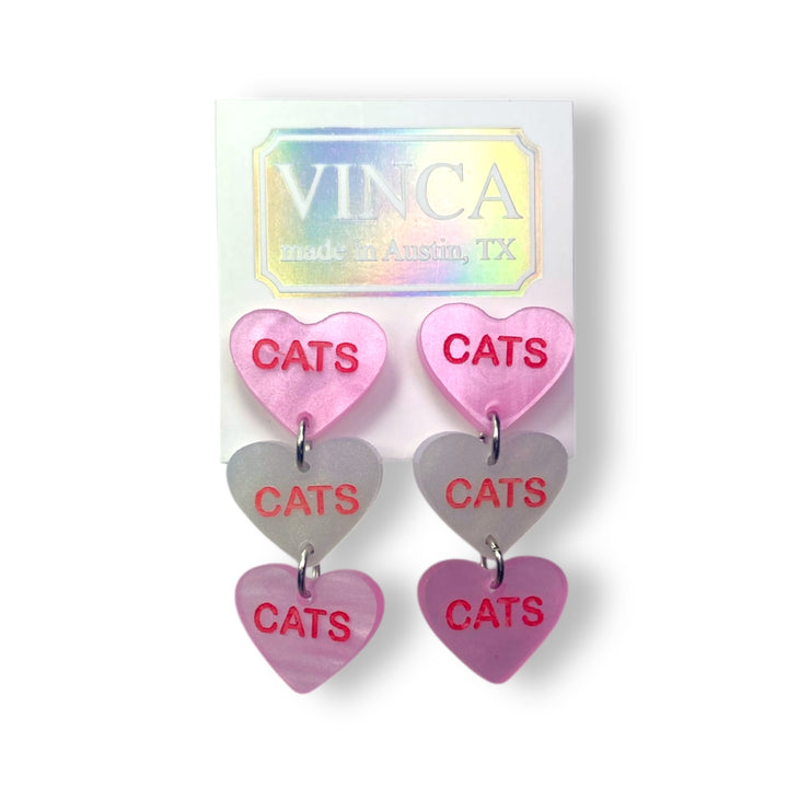 Cats cats cats candy heart earrings in pearl pink and pearl white on a white card set against a white background