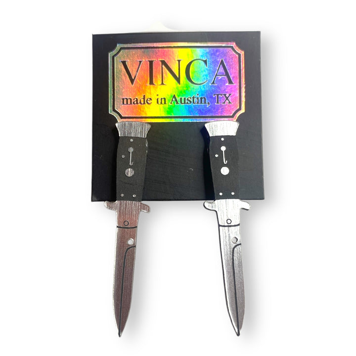 handmade in Austin, TX switchblade knife stud earrings on a black card against a white background