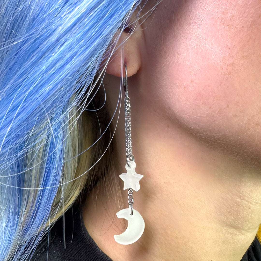 handmade star and moon earrings glow in the dark on model with colorful hair