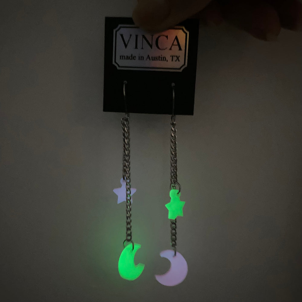 Our limited edition Moon & Star dangle earrings hang from a branded Vinca card as they glow in the dark. 