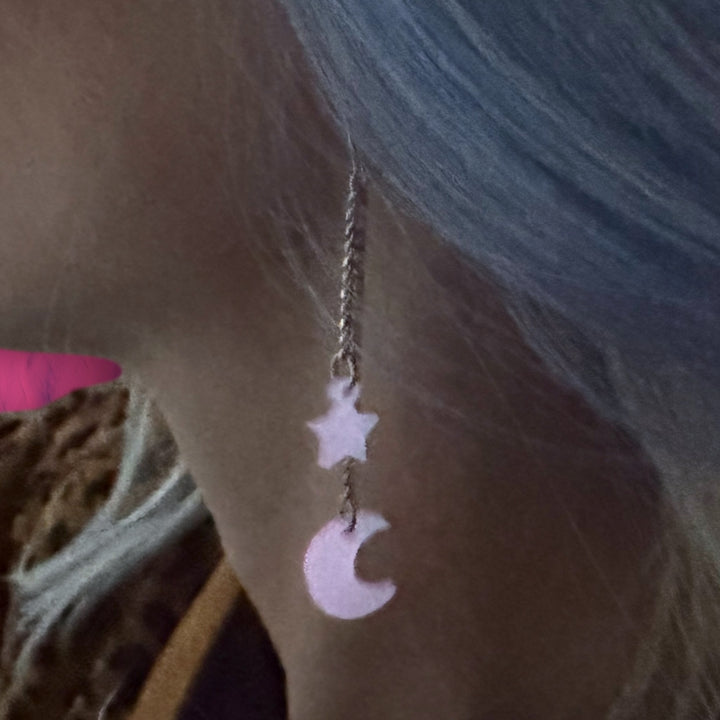 Handmade glow-in-the-dark star and moon dangle earrings with stainless steel findings. 