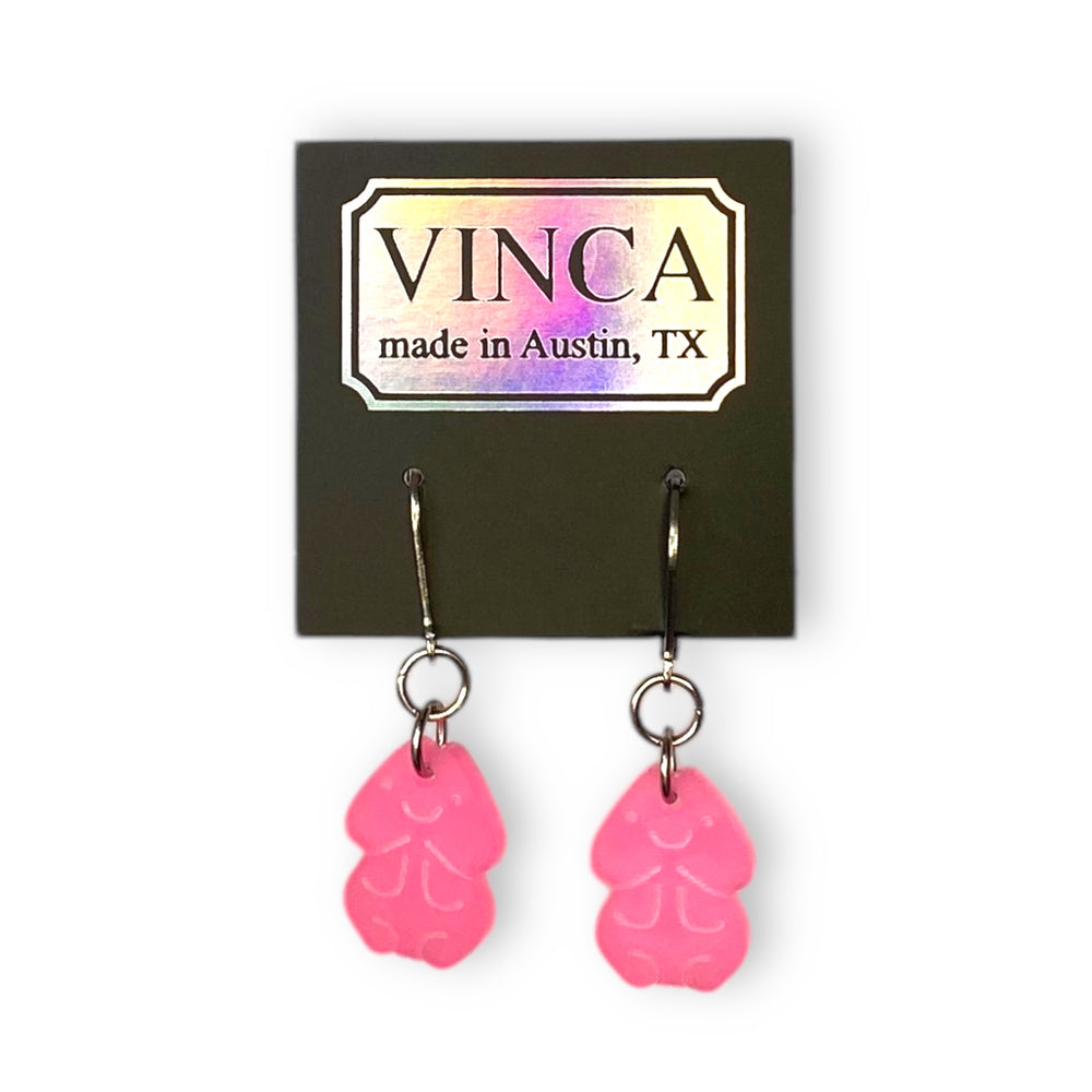 Glow-in-the-dark pink penis earrings are on stainless steel findings and on a black branded Vinca card.