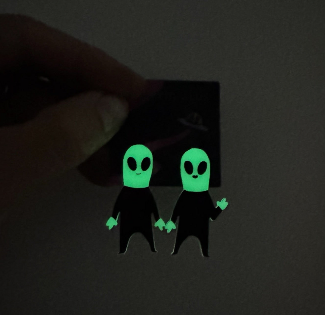 Handmade glow-in-the-dark Cryptid Club Alien earrings have surgical steel posts. 