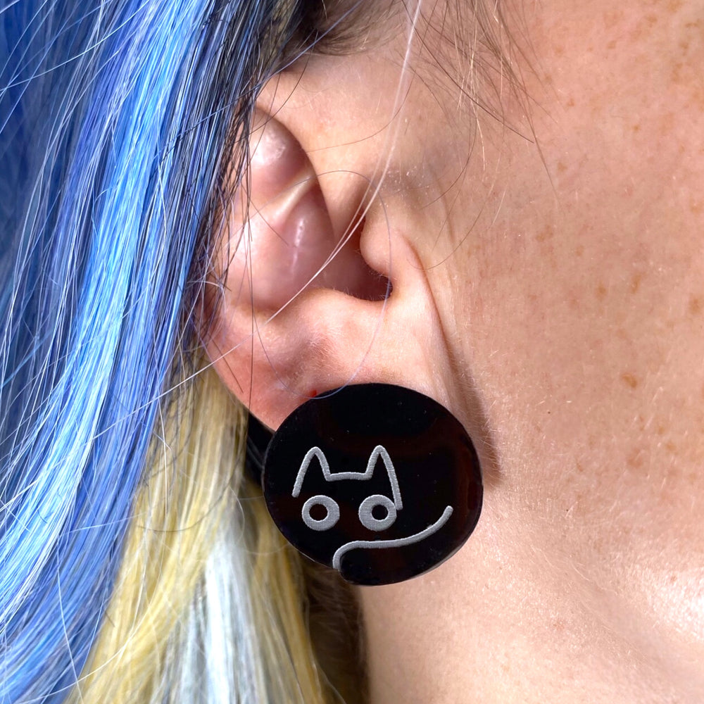 Our handmade Sarah's Scribbles earring on a woman with bright blue hair. 