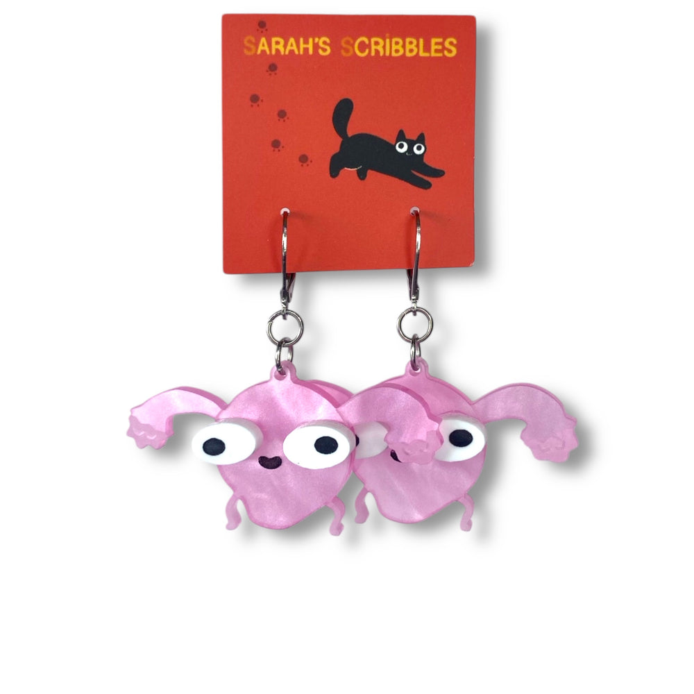 Our handmade Sarah's Scribbles dangle Uterus earrings are on a red Sarah's Scribbles branded card.