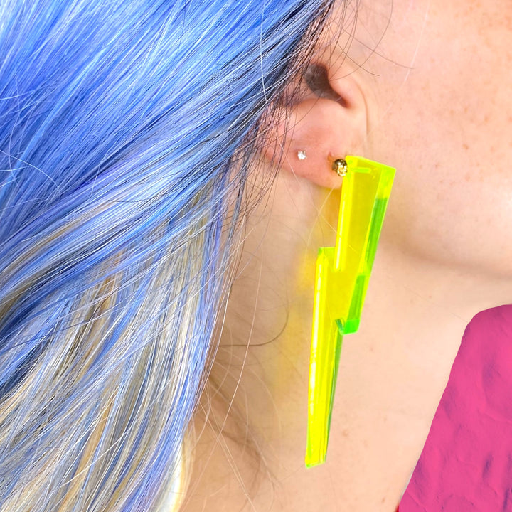 Handmade, transparent green lightning bolt earring on a woman with blue hair.