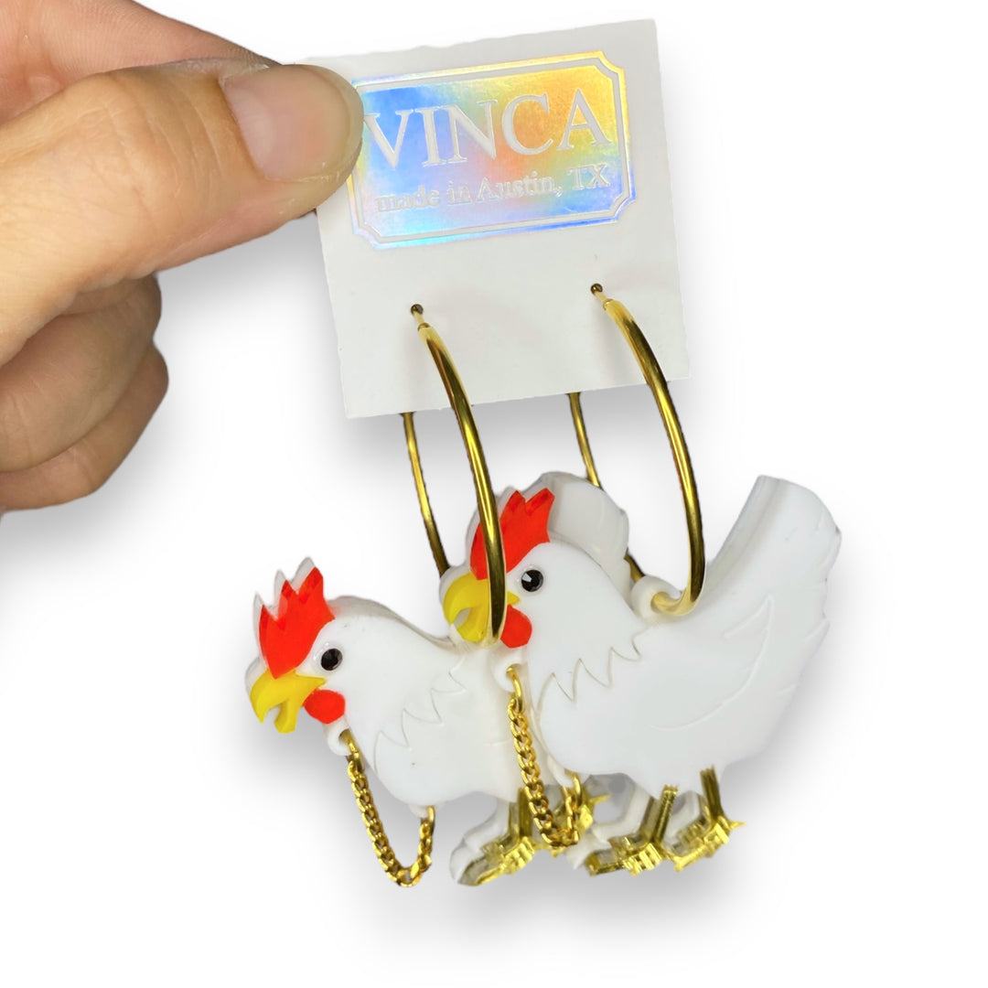 Headless Chicken Earrings held on a package