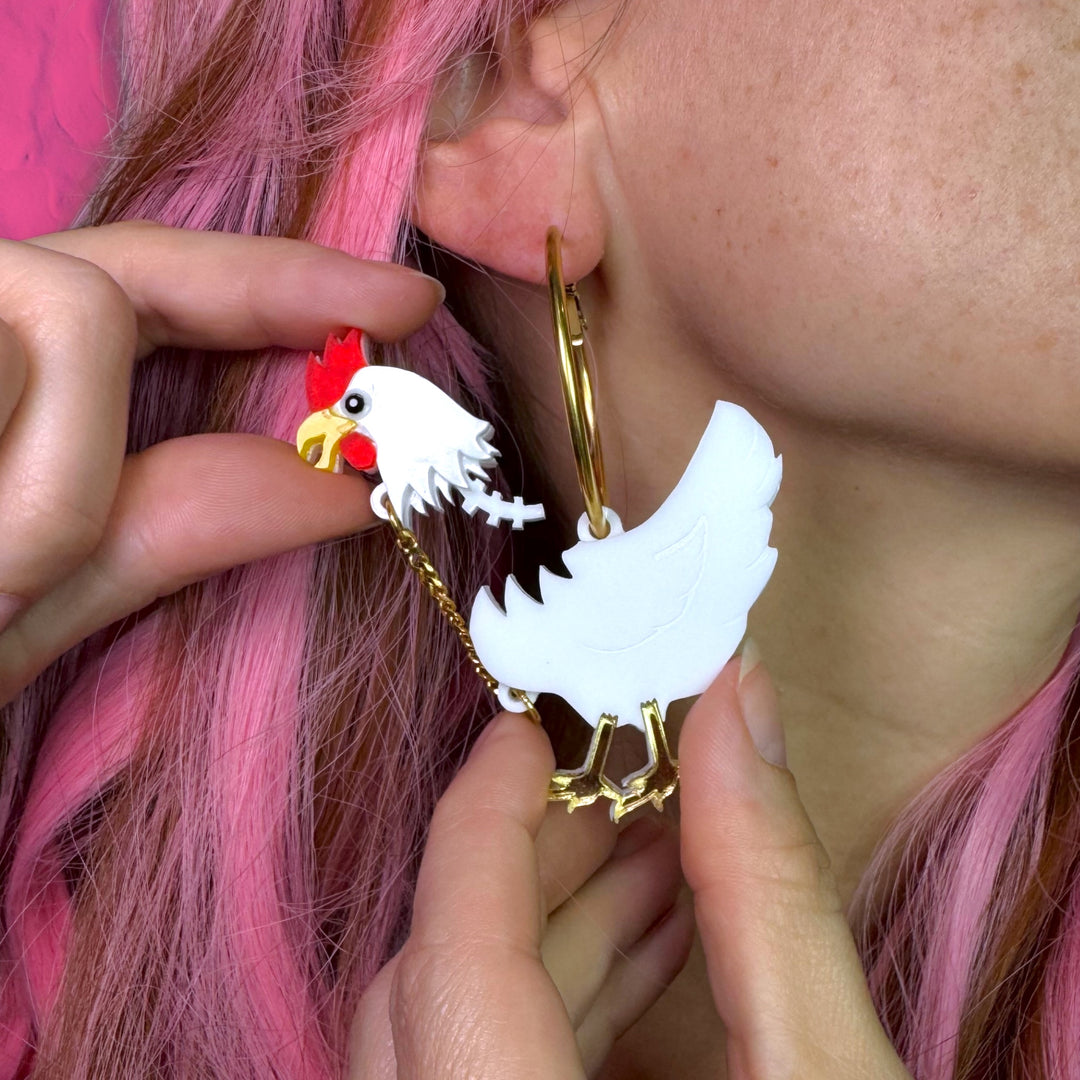 handmade white chicken earrings with a removeable head and the spine sticking out as worn by an alt girlie with pink haircut