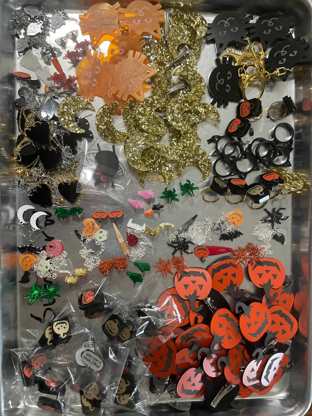Assorted Halloween-themed Mini Mystery Bag accessories on a metal tray