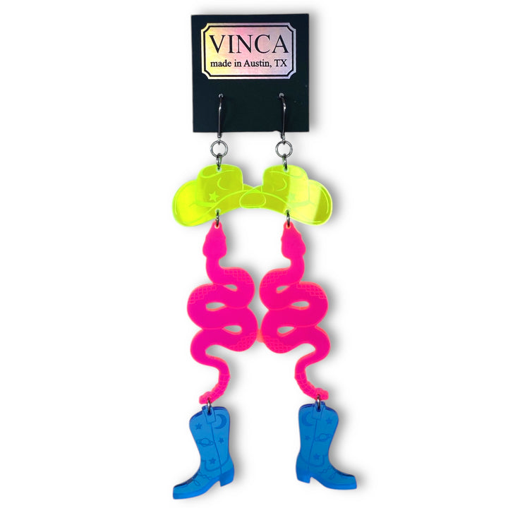 Our Neon Cowboy Earrings are shown on a Vinca branded black card and floating on a white background.