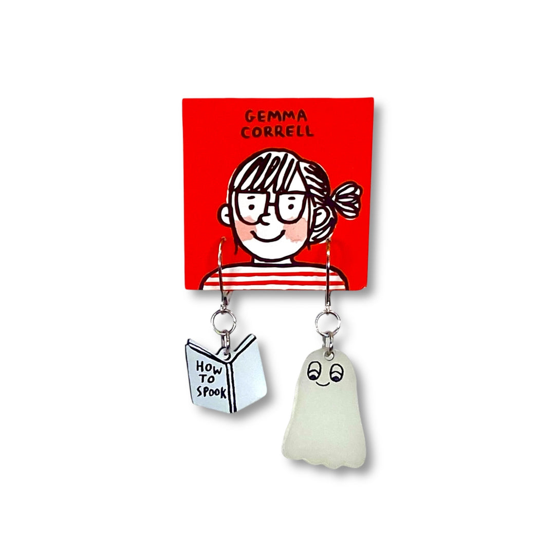 Officially licensed Gemma Correll dangle earrings with spooky glow-in-the-dark ghost and book design on a red card. 