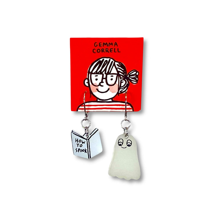 Officially licensed Gemma Correll dangle earrings with spooky glow-in-the-dark ghost and book design on a red card. 