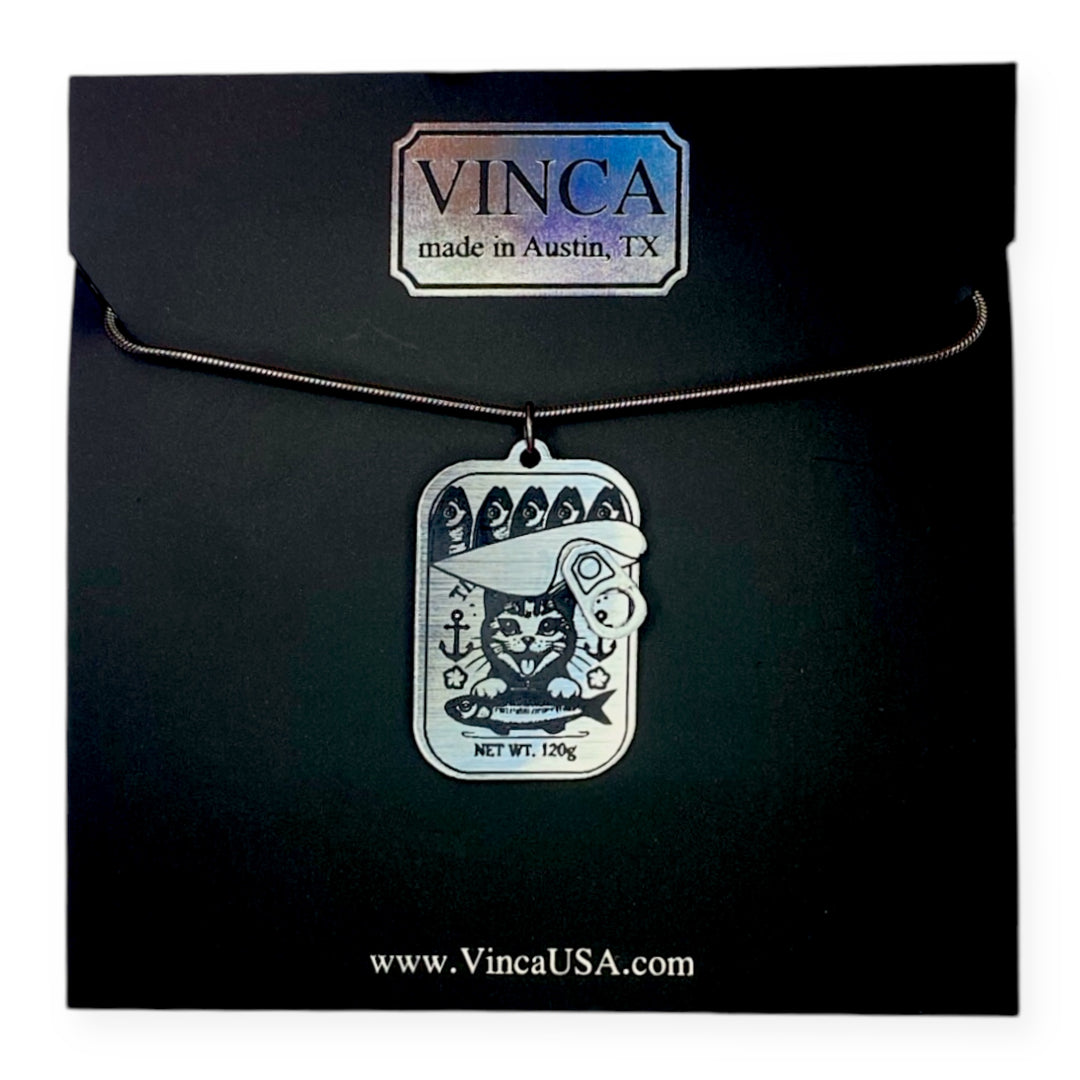 Necklace with our Kitten Breath Tinned Fish cat-themed pendant in black card packaging.