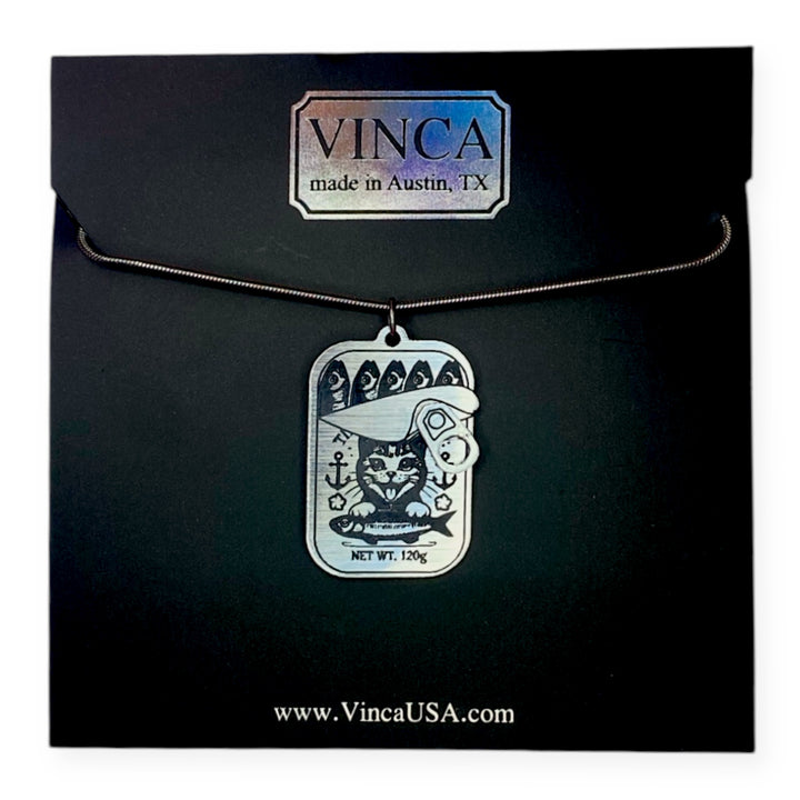 Necklace with our Kitten Breath Tinned Fish cat-themed pendant in black card packaging.