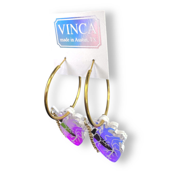 Perfect for soft horror, pastel goth and soft Halloween looks. Iridescent anatomical heart earrings slide onto gold plated stainless steel hoops with a removable plastic knife.