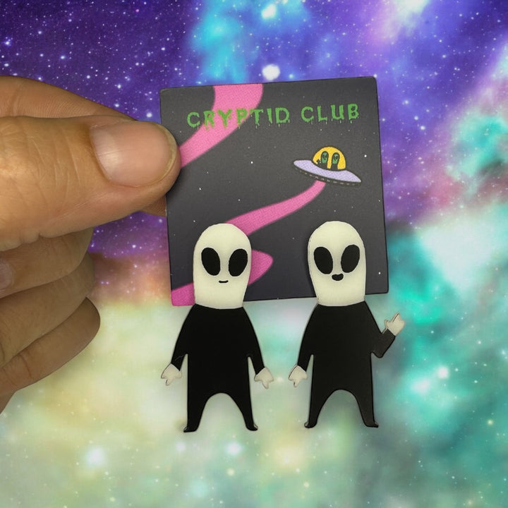 Sara Scribbles' Cryptid Club alien earrings glow-in-the-dark and are on surgical steel posts. 