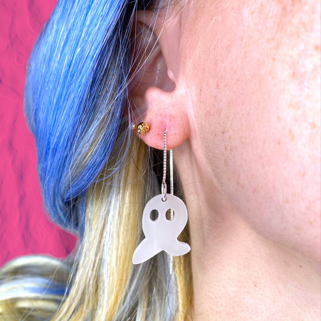 A woman with blue hair wears Sarah's Scribbles Fresno Nightcrawler ear threader earrings. 