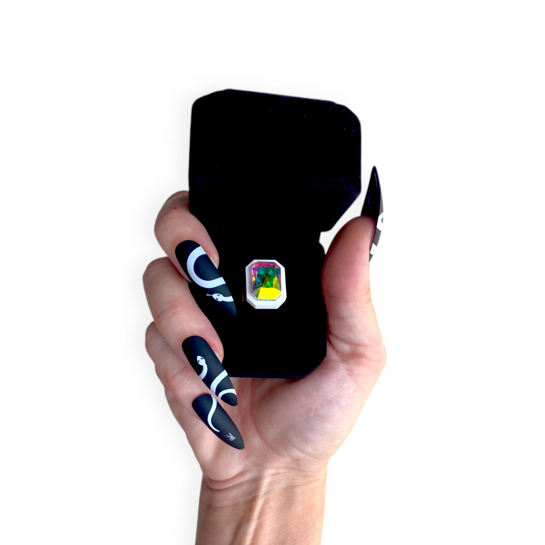 Black velvet Sorceress's Apprentice adjustable ring case with ring inside and held by a hand.