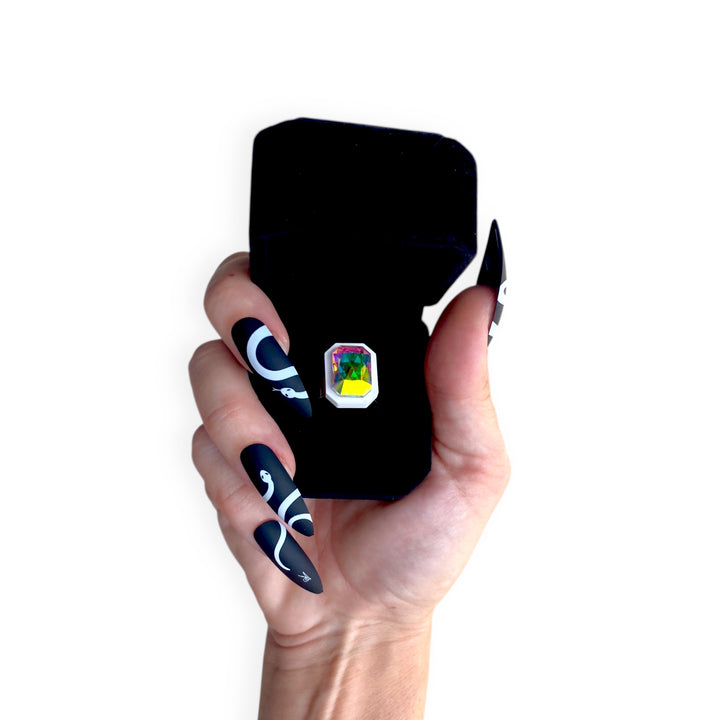 Black velvet Sorceress's Apprentice adjustable ring case with ring inside and held by a hand.