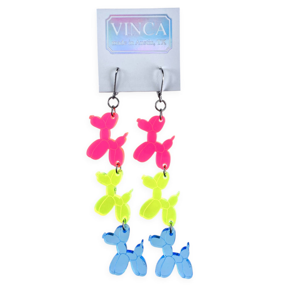 Transparent neon blue, green and pink balloon dog stacked earrings on stainless steel hook clipped through a white branded Vinca card. Carded Vica earrings sit against a white background.