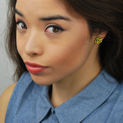 Young woman wearing yellow 45 record adapter earrings.
