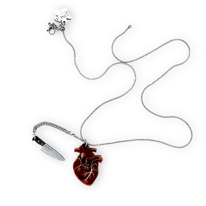 Transparent frosted red anatomical heart necklace with plastic brushed silver tone removable knife.