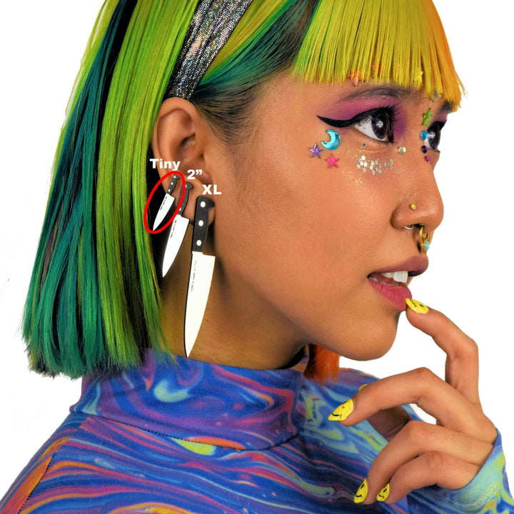 decora model wears three sizes of knife earrings. The tiny 1" knives are circled.