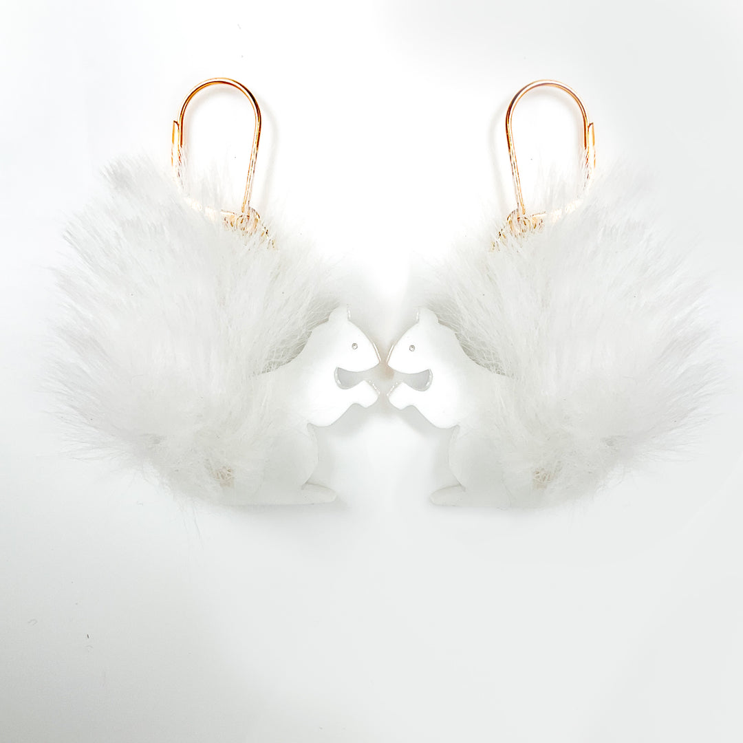 White, fluffy squirrel earrings on gold hooks set against a white background.