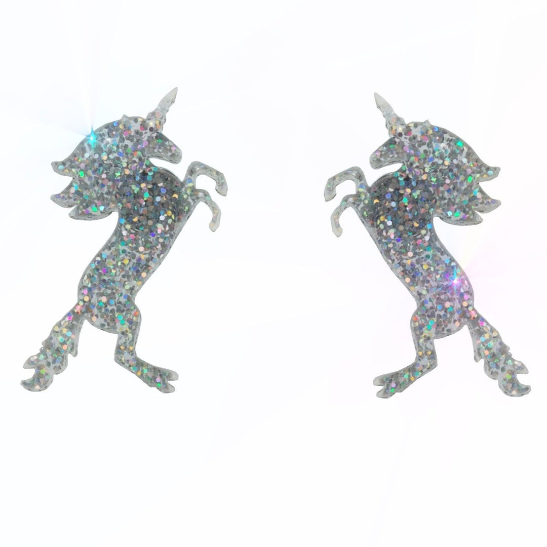 Glitter hologram unicorn earrings floating on a white background.