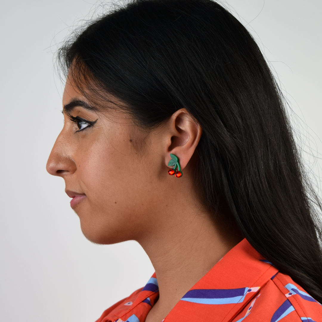 Cute handmade cherry earrings on a model with winged eyeliner