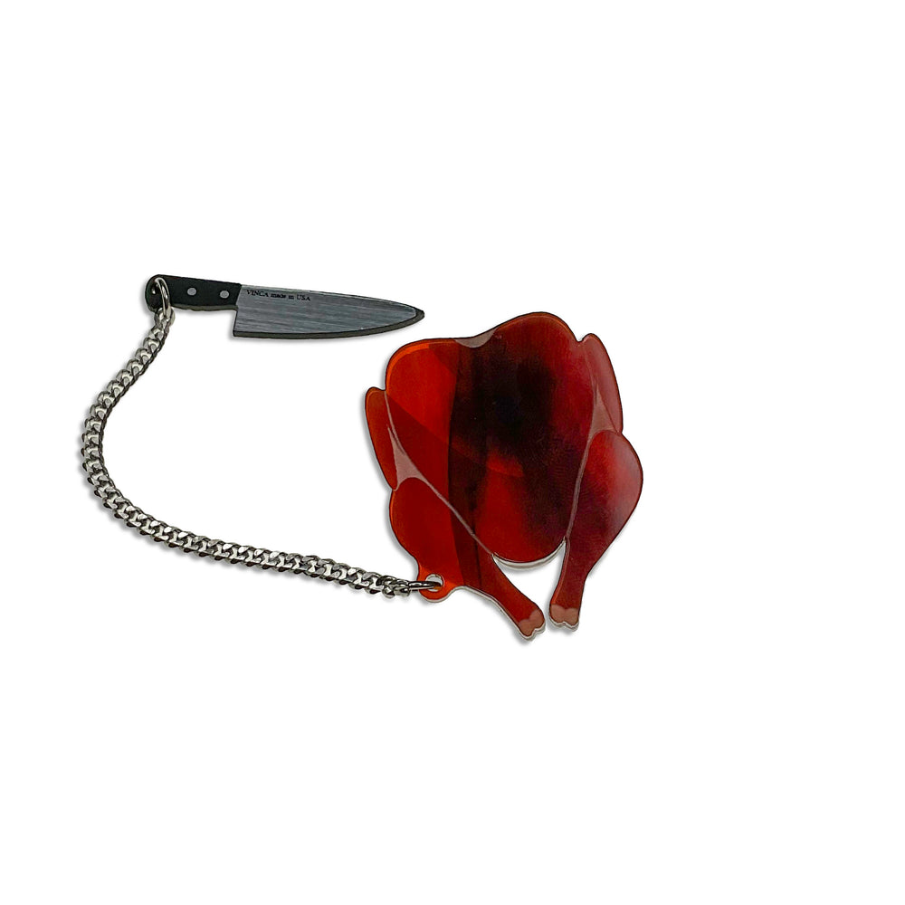 Handmade roasted turkey brooch pin with the chef's knife removed on a white background. 