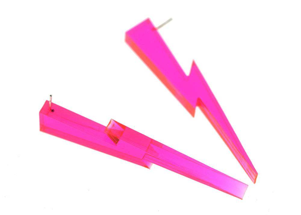 Transparent neon pink lighting bolt earrings floating on a white background.