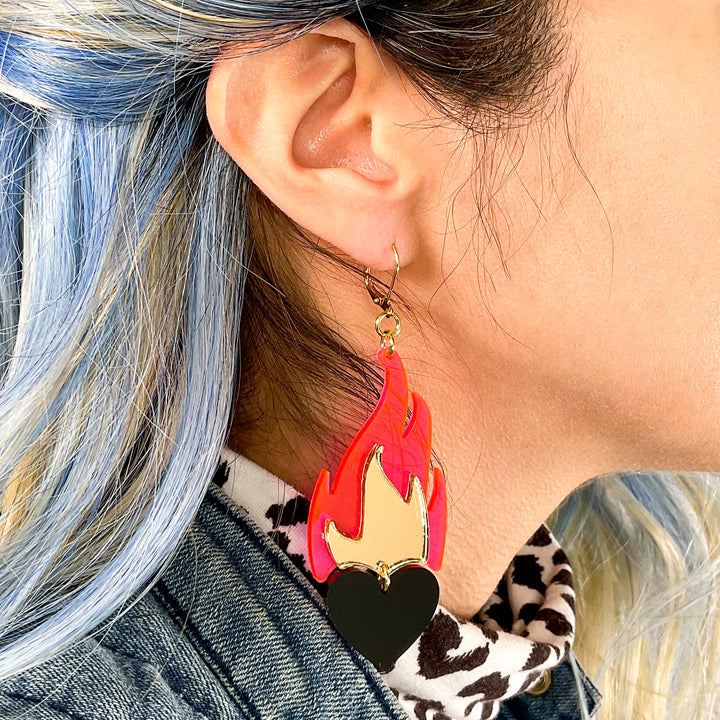 Love A La Flambé earrings in hot pink, solid black and mirror gold on a woman with blue hair.